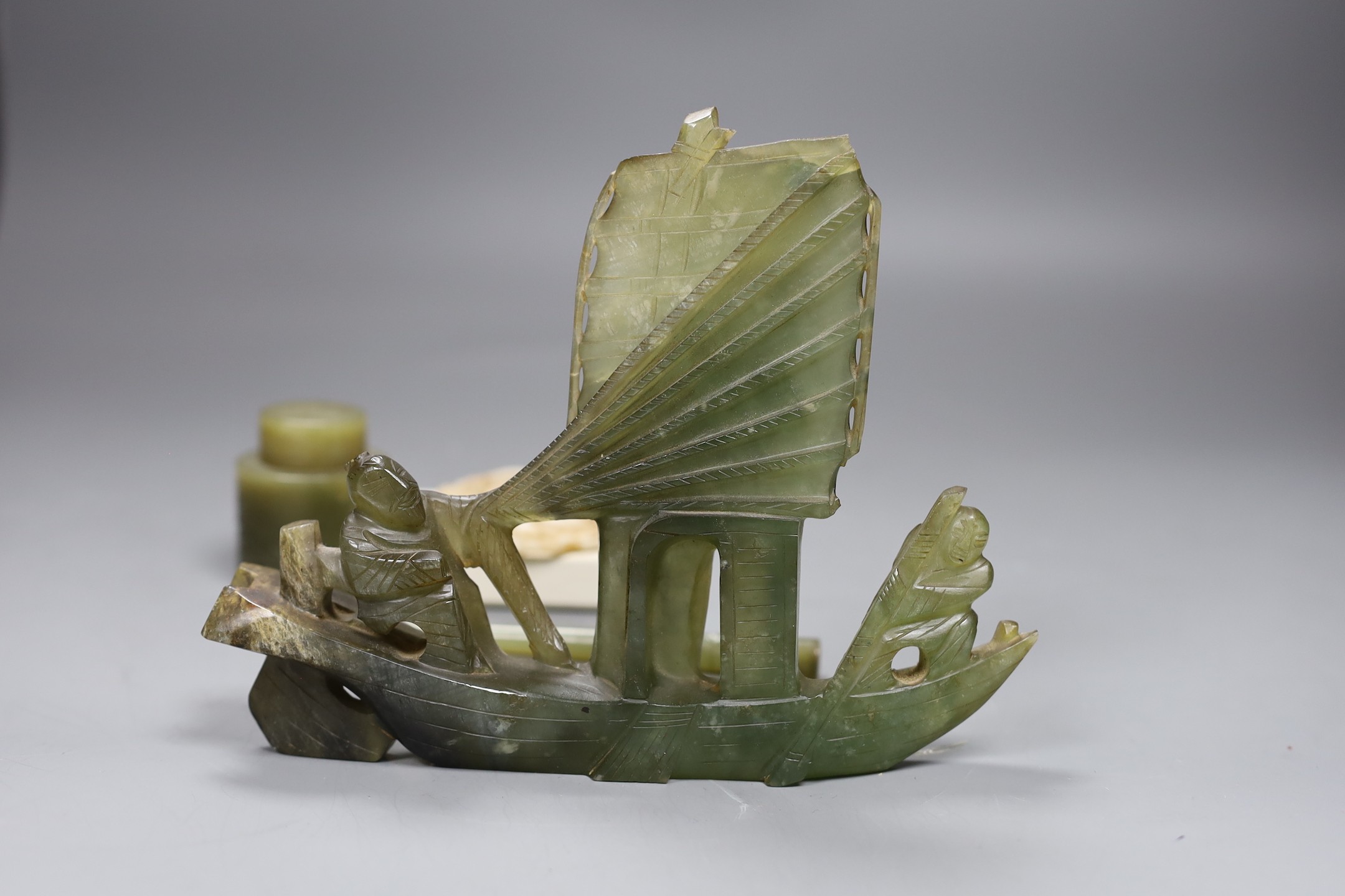 A Chinese bowenite jade desk set (7) and a plaque, model of junk 16cms high